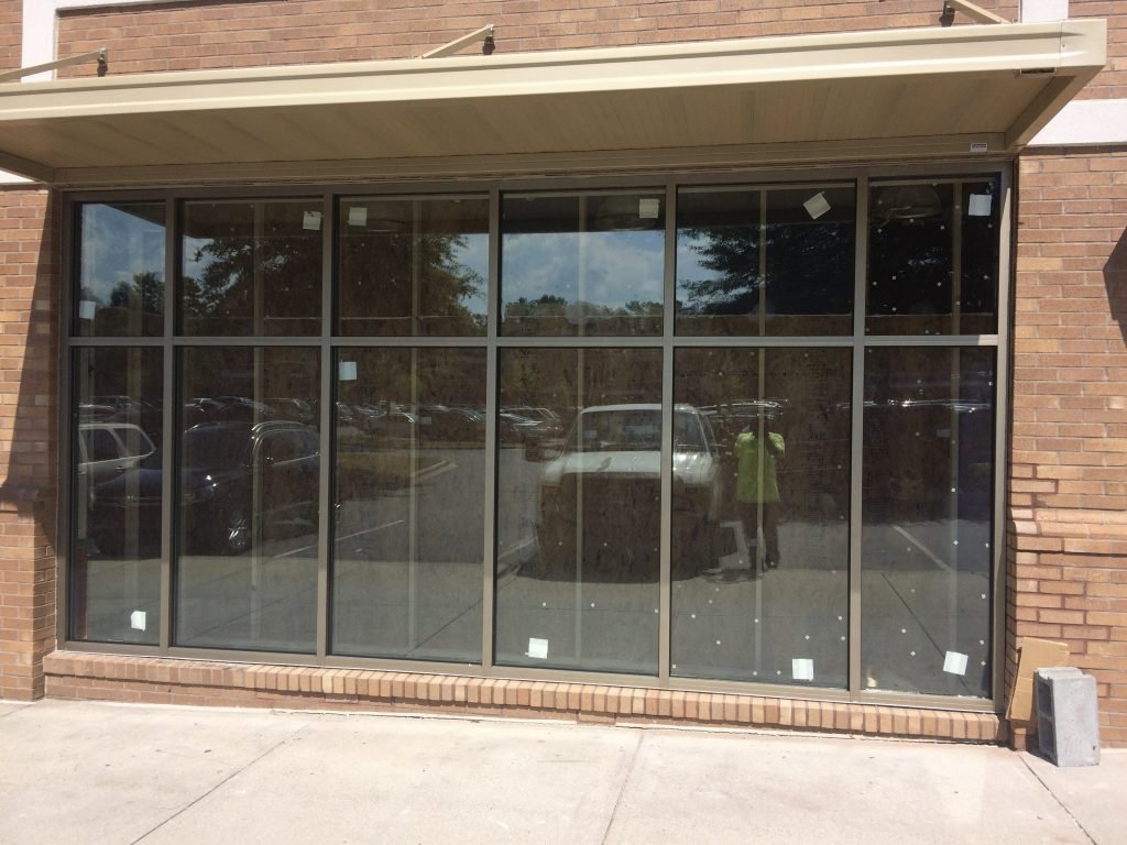Multiple-panel glass storefront doors on brick facade