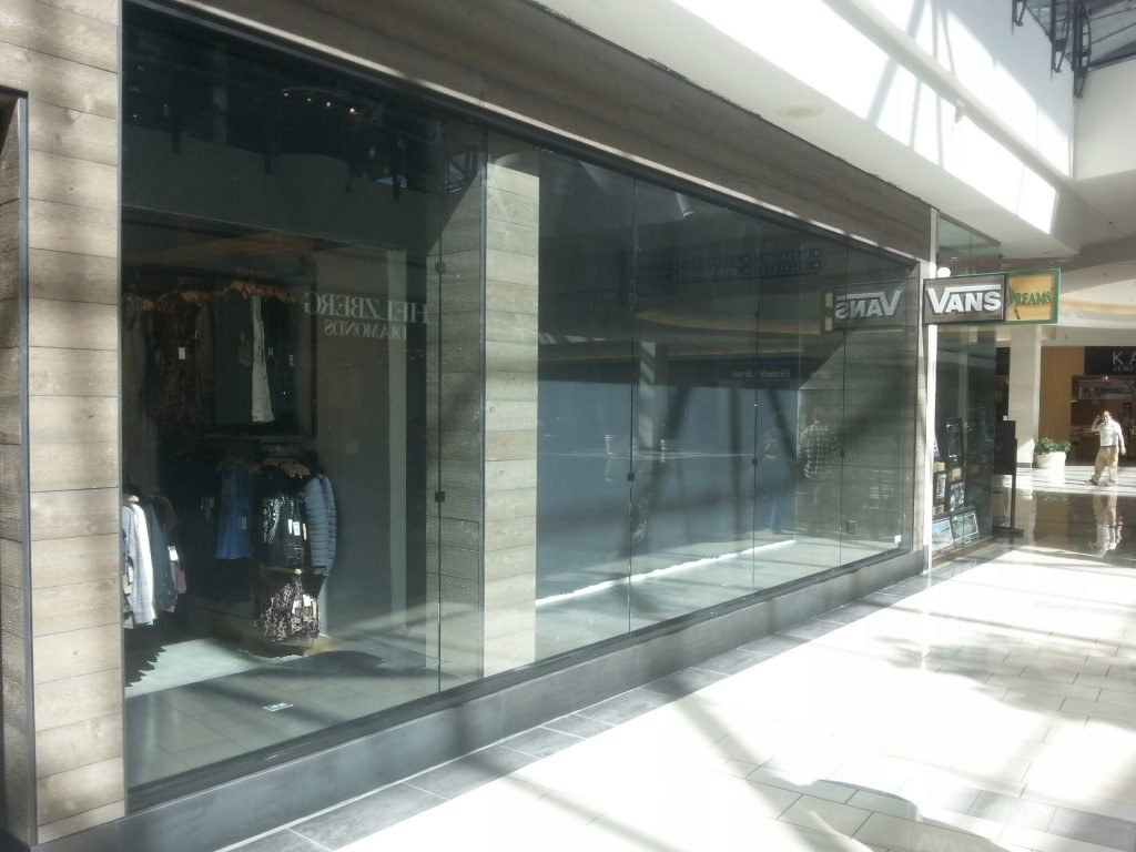 Sleek glass storefront doors in shopping mall interior